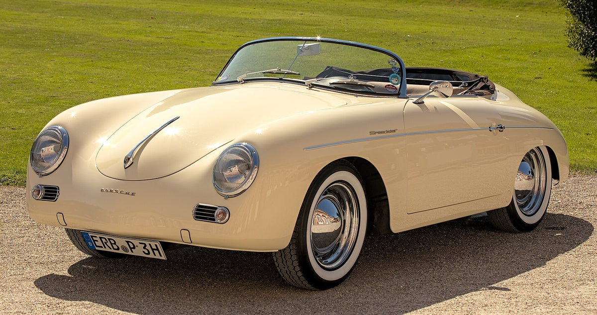 Cream Porsche 356 A Speedster parked on gravel beside a lawn