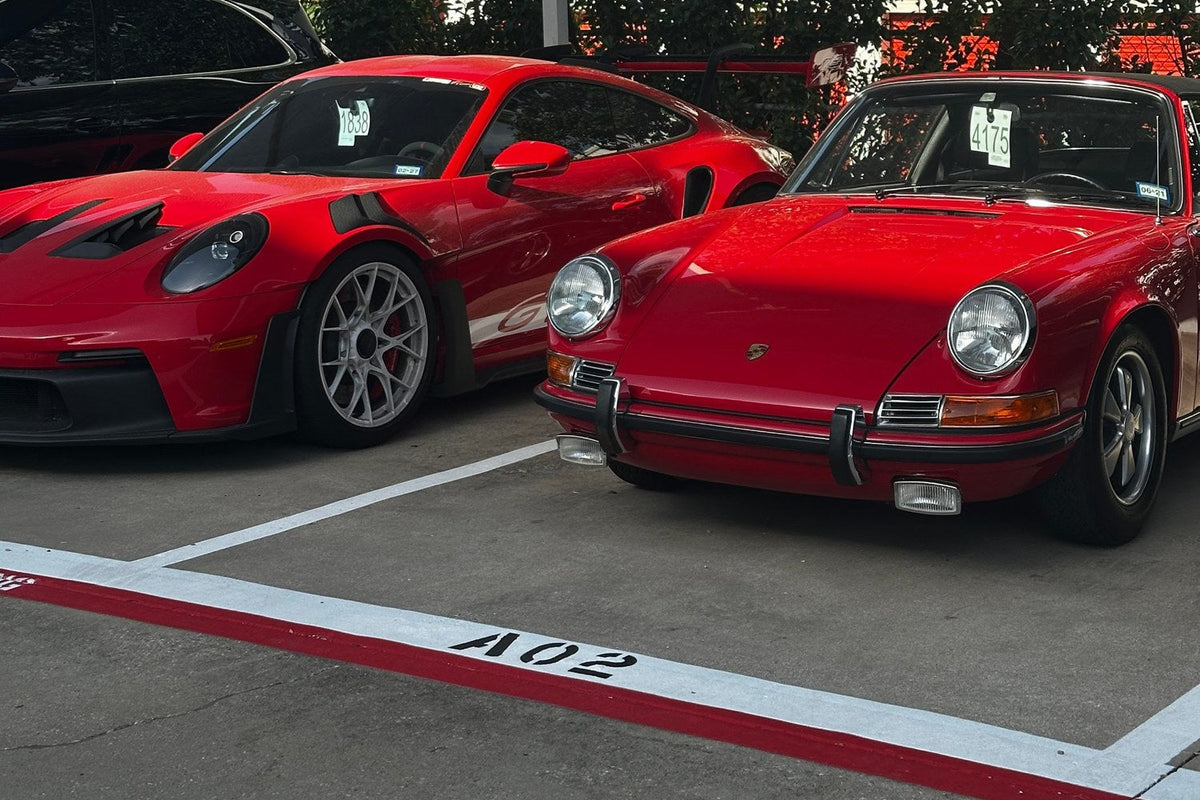 A current red Porsche 911 GT3 RS parked beside an early red Porsche 911